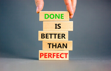 Done is better than perfect symbol. Concept words Done is better than perfect on wooden blocks. Beautiful grey background. Businessman hand. Business, done is better than perfect concept. Copy space.