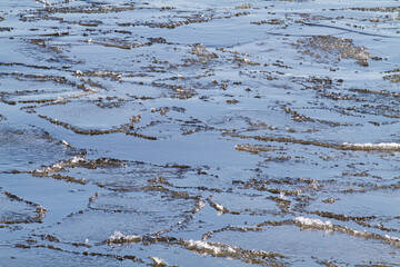 broken river ice floats on the surface of the water
