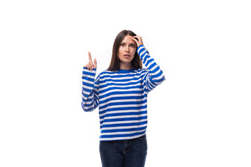 Obraz na płótnie Canvas pretty young smiling brunette woman in a striped blue sweatshirt on a white background