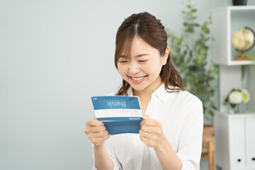 貯金通帳を手に笑顔の女性