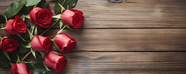 Red roses adorn a vintage brown wooden background with copyspace