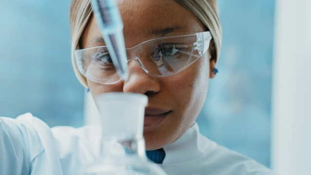 Medical Research Laboratory: Portrait of a Beautiful Female Scientist in Goggles Using Micro Pipette for Test Analysis. 