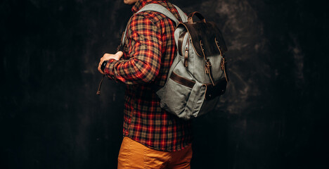 Man with stylish canvas backpack on dark background, back view. Close up