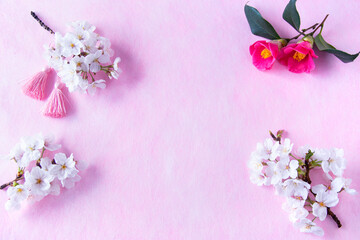 Fototapeta na wymiar 正月イメージ　桜の花と椿の花とタッセルのアレンジメント（ピンクバック）