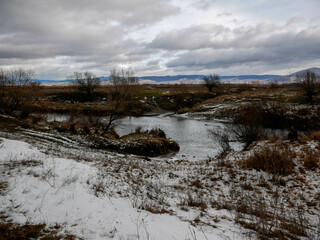 Dirty olt river at wintertime in Transylvania, Romania.