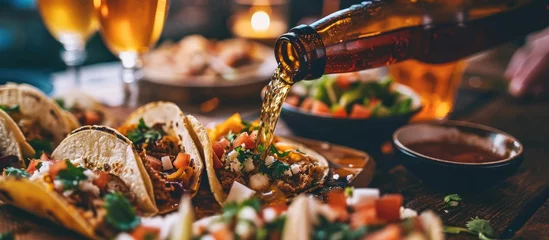  Pouring beer in the presence of Mexican tacos. © AkuAku