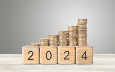 flipping year wooden block and Coins stack.