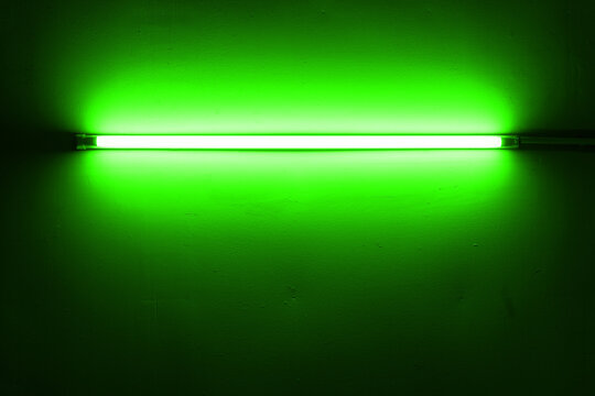 Green neon lamp on a white wall for design