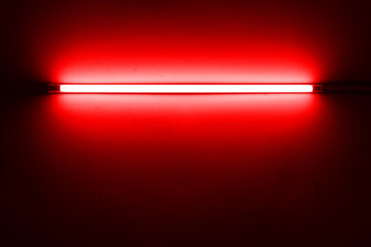 Red neon lamp on a white wall for design