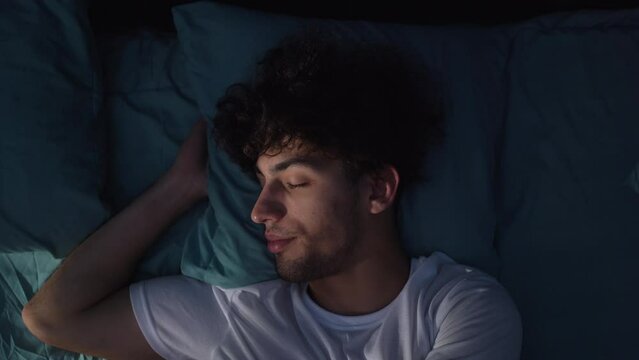Annoyed arabic young man suffering from insomnia, awake in bed at night, unable sleep. Restless people.