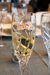 New year dinner served with champagne cava or prosecco wine in crystal glasses on table with christmas tree and garland lights on background