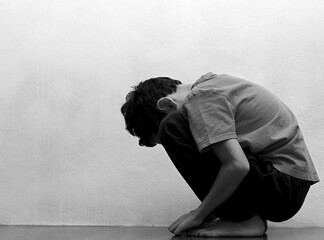 boy praying in poverty on the floor stock image with no help crying alone and all by himself on white background stock photo