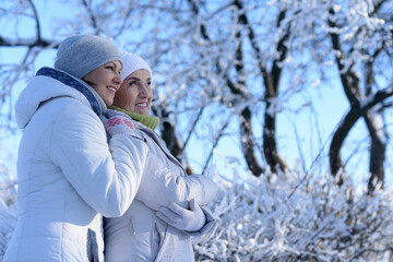 Happy women in winter clothes posing outdoors