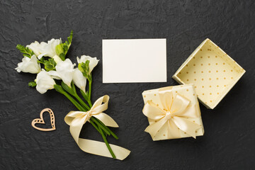 Open gift box, with fresia flower concrete background, top view