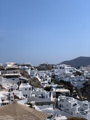 Fototapeta na wymiar Beautiful Oia town on Santorini island, Greece. Traditional white architecture and greek orthodox churches with blue domes over the Caldera, Aegean sea in the beautiful town of Oia. 