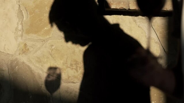 Close up shot winemaker or sommelier is pouring red wine in transparent glass for tasting a flavor and checking a quality in a wine cellar.