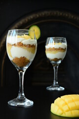 Mango, yogurt and cookies dessert in wineglass