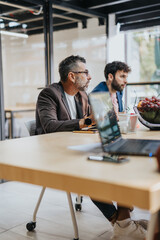 Diverse business group collaborates in an office, discussing market research, strategic planning, and profit growth.