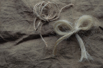 Flax Knots or Bows. Linen fabric background. Copy space.