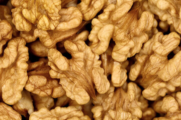 Close-up of peeled walnuts, high detail background of walnut kernels, concept of healthy fats in...