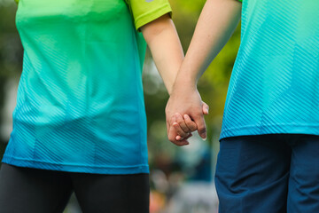 Couple holding arms together while exercise walking in the morning