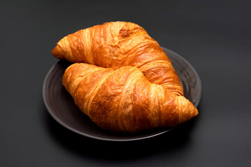 Crispy delicious croissants on a black background. Homemade baking