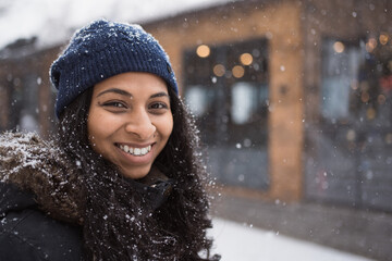 Face portrait of young smiling indian woman outdoors in snowy winter