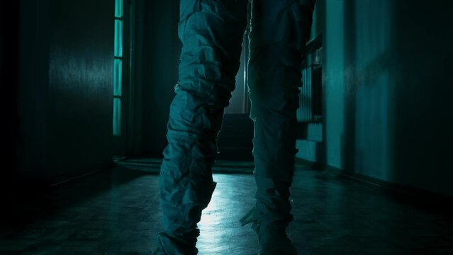 Mummy covered in white cloth ribbons walking in the corridor with flashing lightning, feet close up.