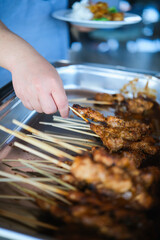 A man took Chicken Satay or Sate Ayam served in one of Indonesian Restaurant for lunch.