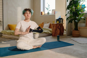 Teen girl with prosthetic arm making fist and palm gesture