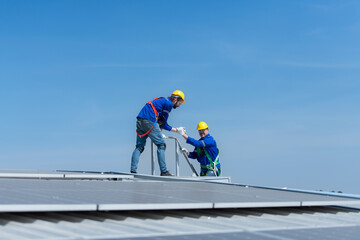 A young technician intern working on solar panels is fear of heights with senior engineers who are...