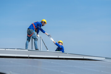 A young technician intern working on solar panels is fear of heights with senior engineers who are...