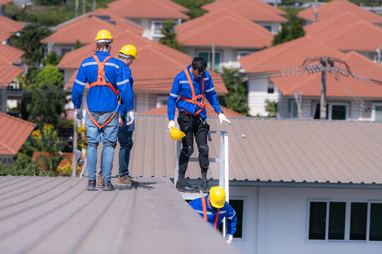After installing and inspecting the performance of the solar cell panels on the factory roof, a group of engineers installing solar panels descends the stairs to go home