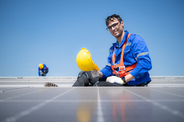 Technician repairing solar panels take off his hat and rest in the scorching sun on a factory roof...