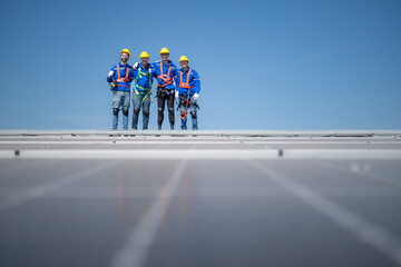 Group of engineers standing on solar panels with blue sky in the background