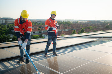 Engineer and technician working on the solar panel on the warehouse roof to inspect the solar panels that have been in operation for some time.