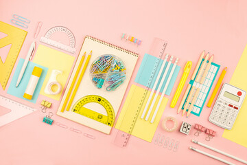stationery items for girls or women on light pink background. Back to school. Female Student's, pupil's or engineer's supplies. Office objects on pastel pink background. Calculator, pen, pencil etc. - 698189534