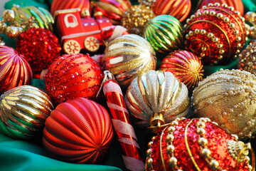 Fototapeta na wymiar New Year's Christmas balls, tinsel and decorations close up. A lot of decoration of golden, red, yellow, green. Striped Christmas balls. Festive beautiful colorful background. Home holidays design.