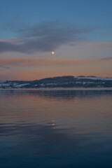 Fototapeta na wymiar Evening light by Lake Mjosa and of rural Toten, Norway, in December.