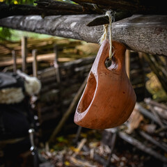 A bushcraft kuksa hand carved with gouges, with a hiking backpack at the background.