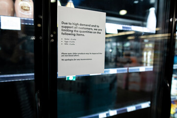 Due to high demand and to support all customers, we are limiting the quantities on the following items butter eggs milk with 2 units empty shelfs and stocks at the grocery store due to coronavirus - obrazy, fototapety, plakaty