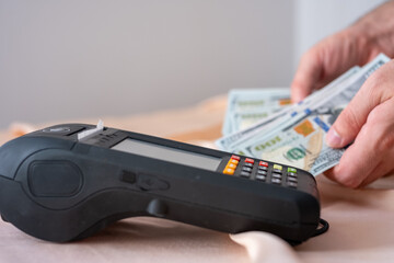 counting american dollars on pos machine on pink background - obrazy, fototapety, plakaty