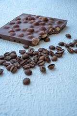 coffee beans and hazelnut chocolates on blue background