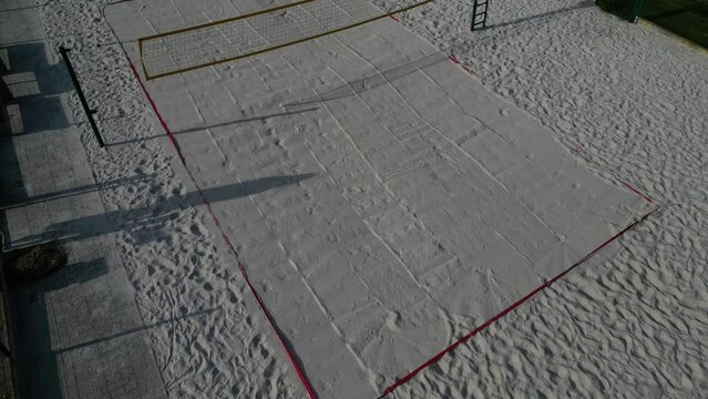 white sand beach volleyball court. white soft dunes fenced with nets. The lines of the playing field are made of blue textile plastic straps