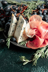 Prosciutto with blue cheese, grapes, and rosemary.