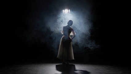 Silhouette of female on black background under spotlight projector in studio. Ballerina in white...