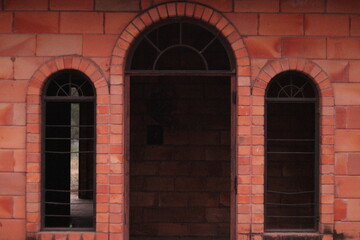 A red Building of chandrashekhar farm at pandala, bhondsi made up of Red Stone concrete blocks with arch windows and gate, shaded ceiling