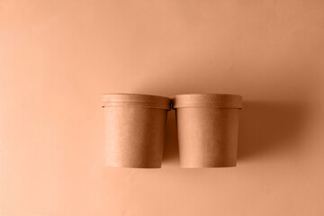 Empty paper Biodegradable cups containers for food and soup on the background of Trendy color of year 2024 - Peach Fuzz.