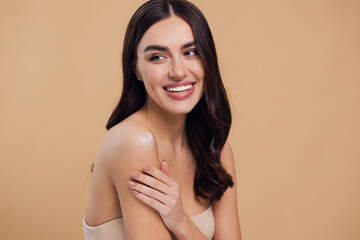 Beauty portrait of laughing beautiful half naked woman smiling and applying face cream