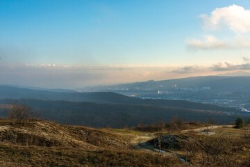 panorama of the city of Novorossiysk (southern Russia) off the Black Sea coast from the heights of the Western Caucasus mountains in the sunny pre-evening hour of late autumn